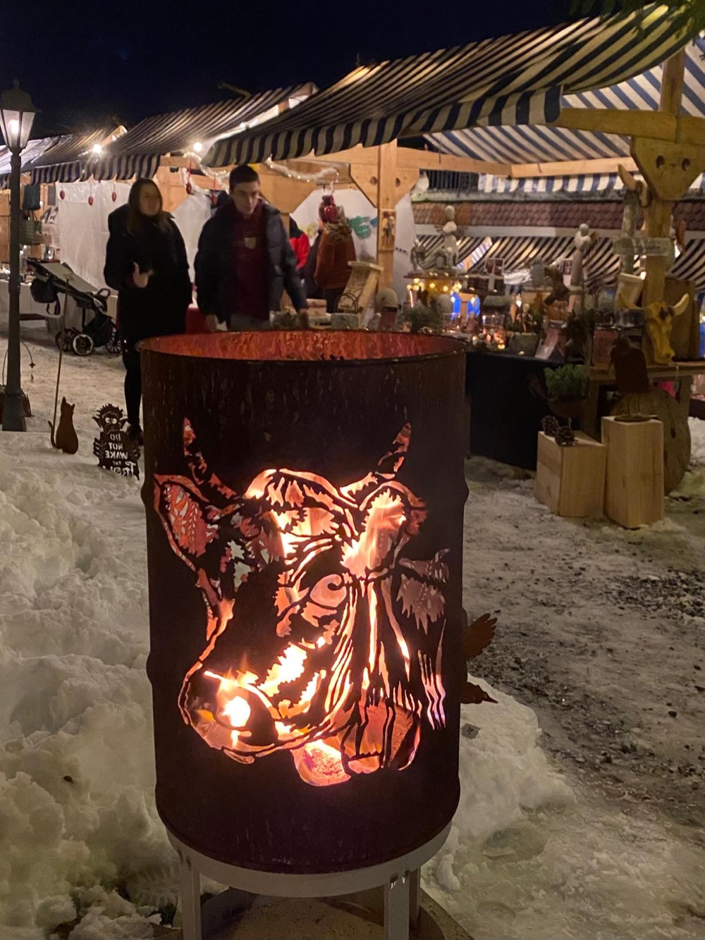 Feuertonne mit Kuh-Motiv zwischen den Marktständen